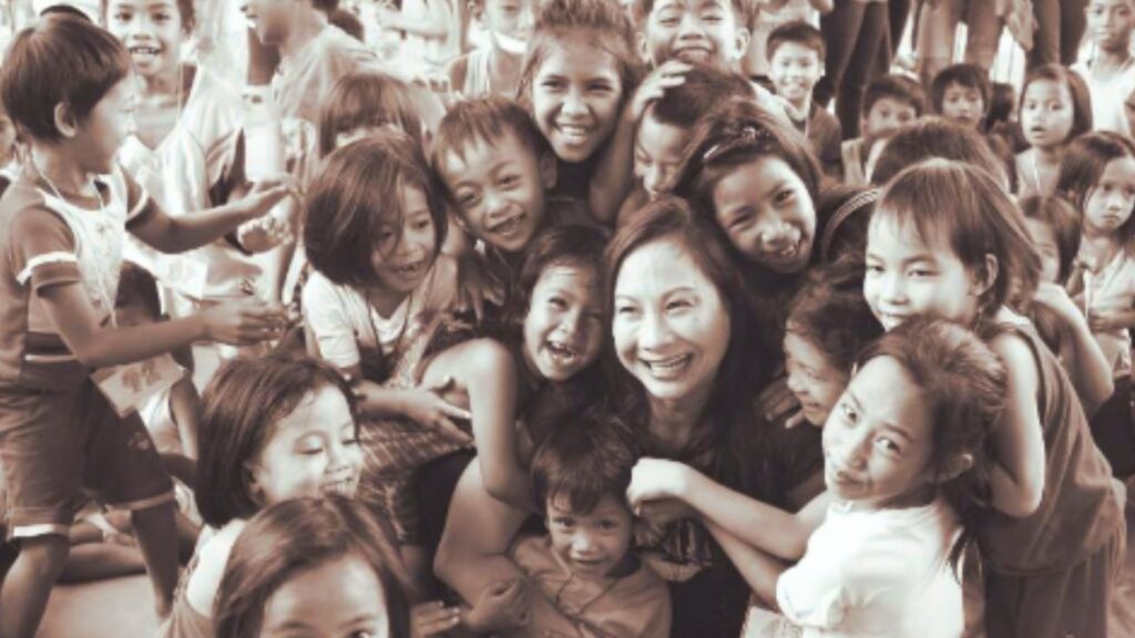 Children from the Fishes & Loaves feeding program gathered around a volunteer